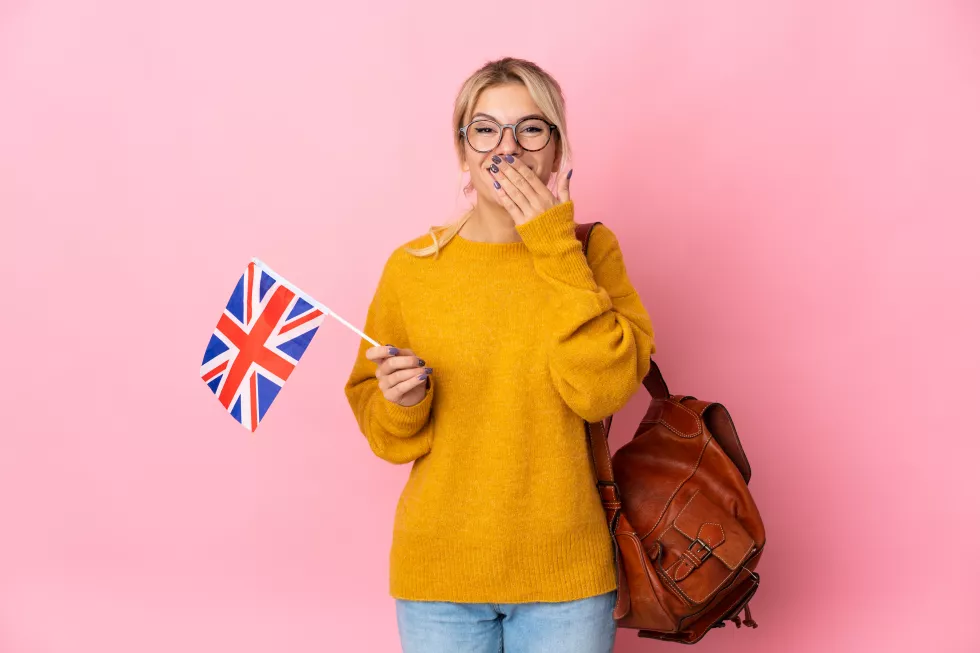 young-russian-woman-holding-united-kingdom-flag-isolated-pink-background-happy-smiling-covering-mouth-with-hand