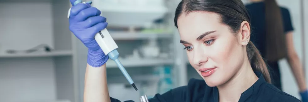 Cosmetology-Masters-test-smiling-woman-looking-at-the-test-tube-in-her-hand-while-usi