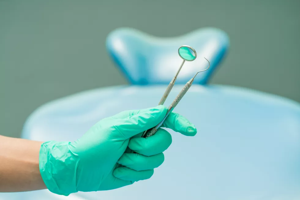 cropped-hand-dentist-holding-dental-equipment