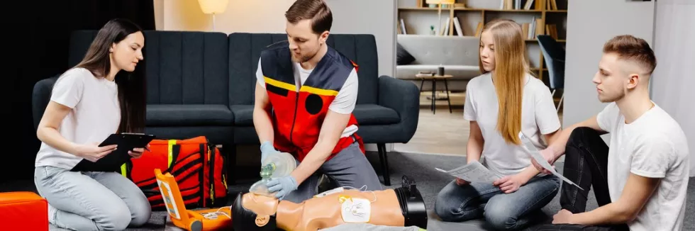 Security-test-young-man-instructor-helping-to-make-first-aid-heart-compres