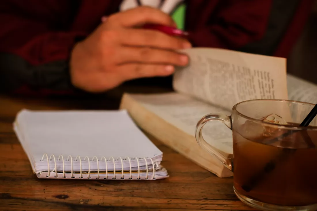 midsection-man-reading-book-table
