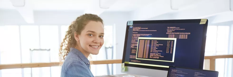 Web-Application-Developer-test-portrait-of-female-it-developer-smiling-at-camera-while-typi