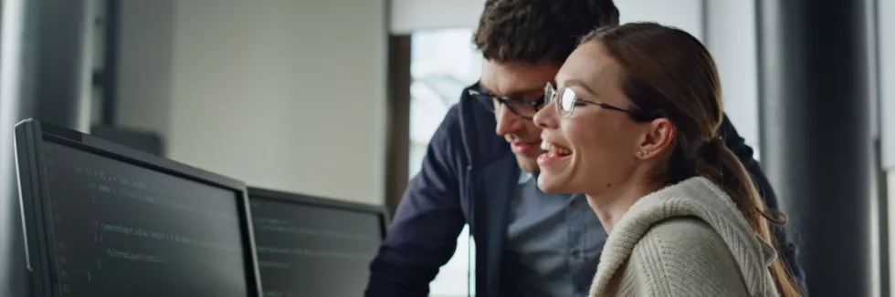 Artificial-Intelligence-AI-test-smiling-it-intern-discussing-software-code-with-supervisor-f