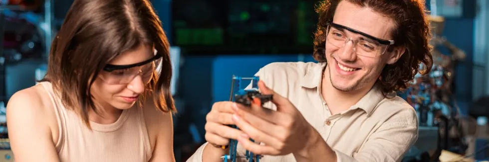 Artificial-Intelligence-and-Robotics-Masters-test-young-man-and-woman-in-protective-glasses-doing-experiments