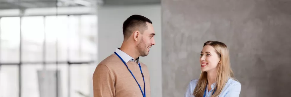 Business-and-languages-B-L-test-man-and-woman-with-conference-badges-at-office