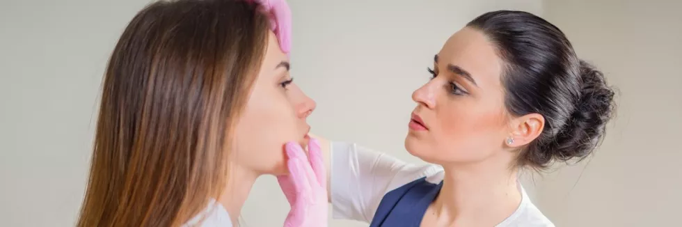 Clinical-Cosmetology-Masters-test-professional-cosmetician-examining-face-skin-of-girl-in-clin