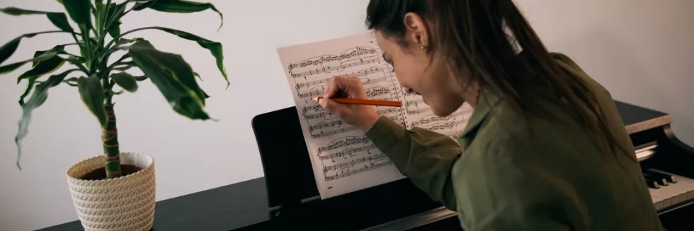 Composition-and-Theory-of-Music-Masters-test-happy-woman-playing-piano
