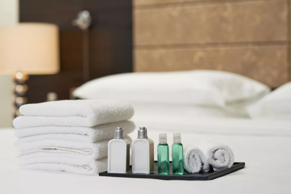 liquid-shampoo-shower-gel-near-towels-bed