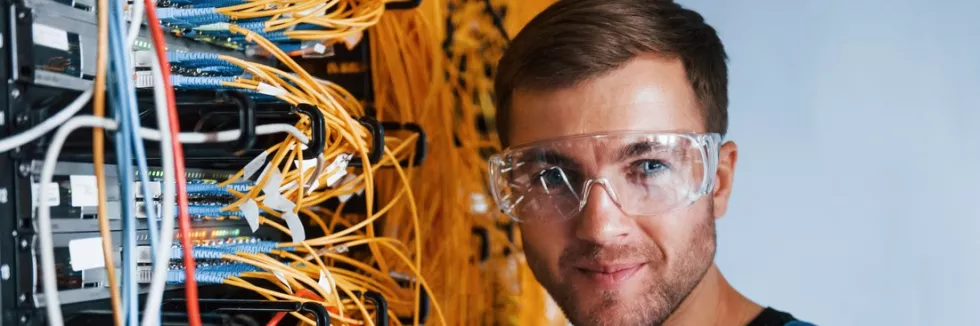 Computer-Network-Administrator-Masters-test-young-man-in-protective-glasses-works-with-internet-equipmen