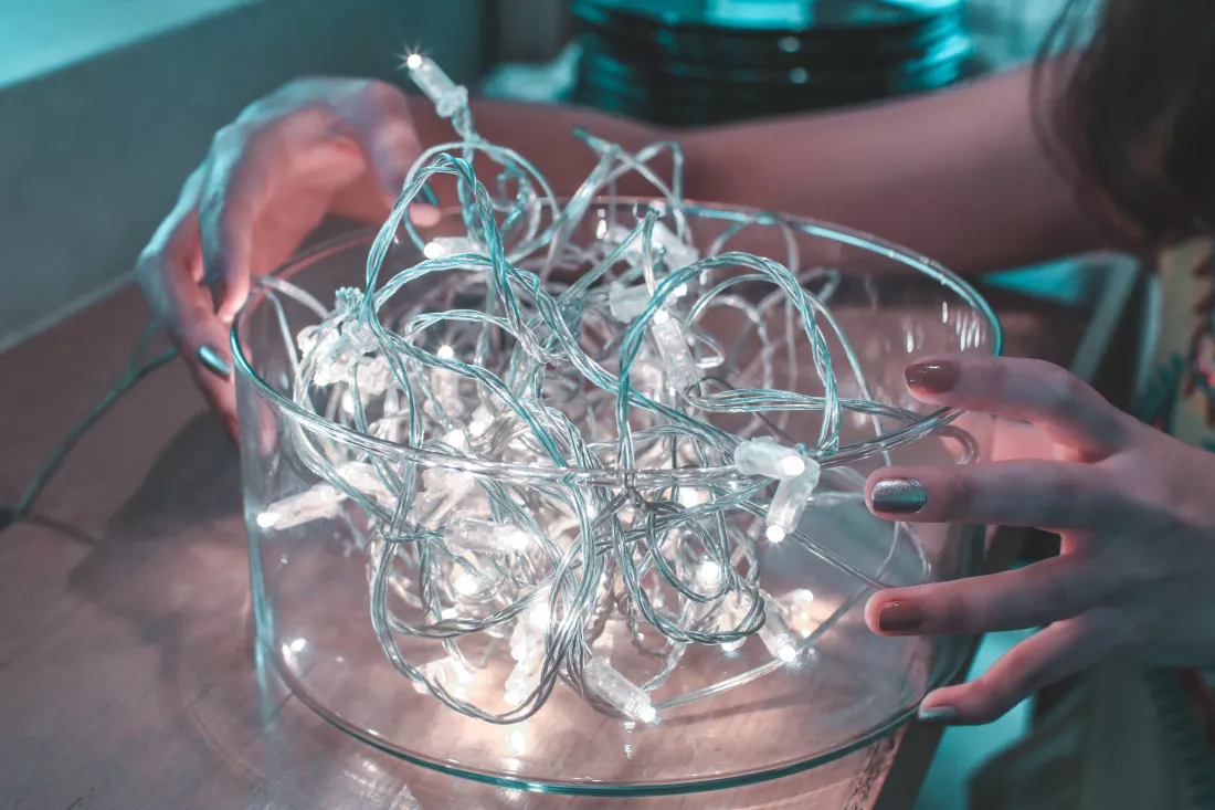 cropped-image-woman-with-illuminated-string-lights-bowl-table