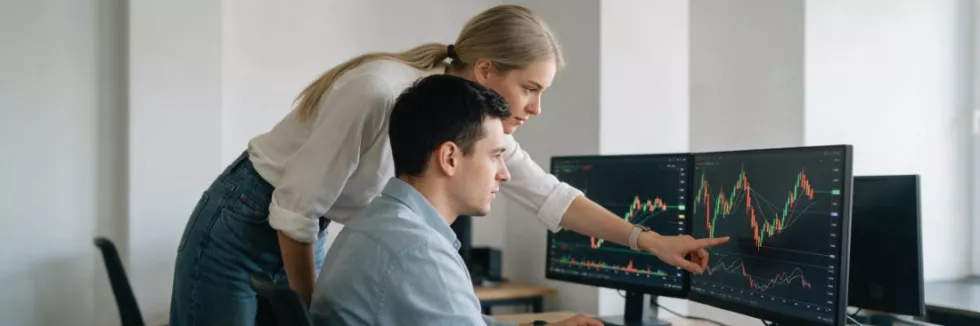financial-analysts-studying-market-charts-on-two-monitors