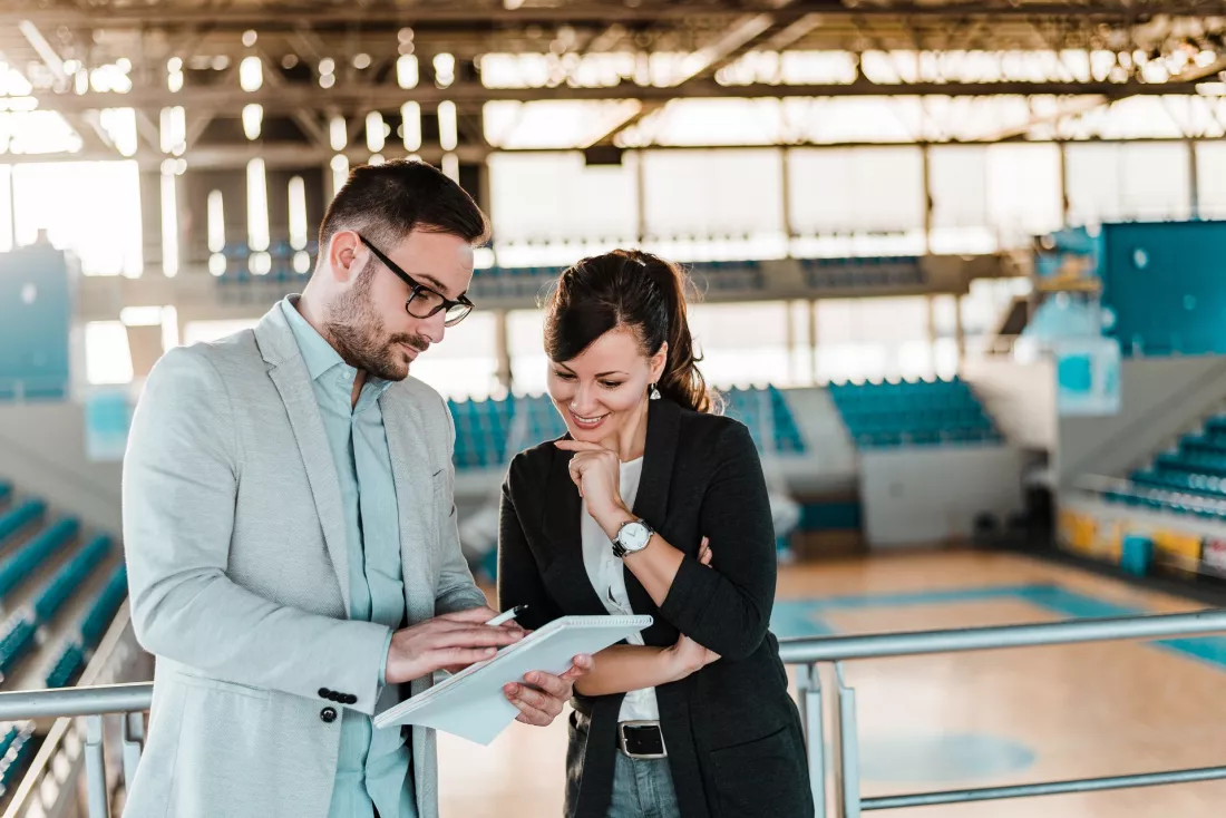 Two sport managers discussing plans in a sports hall