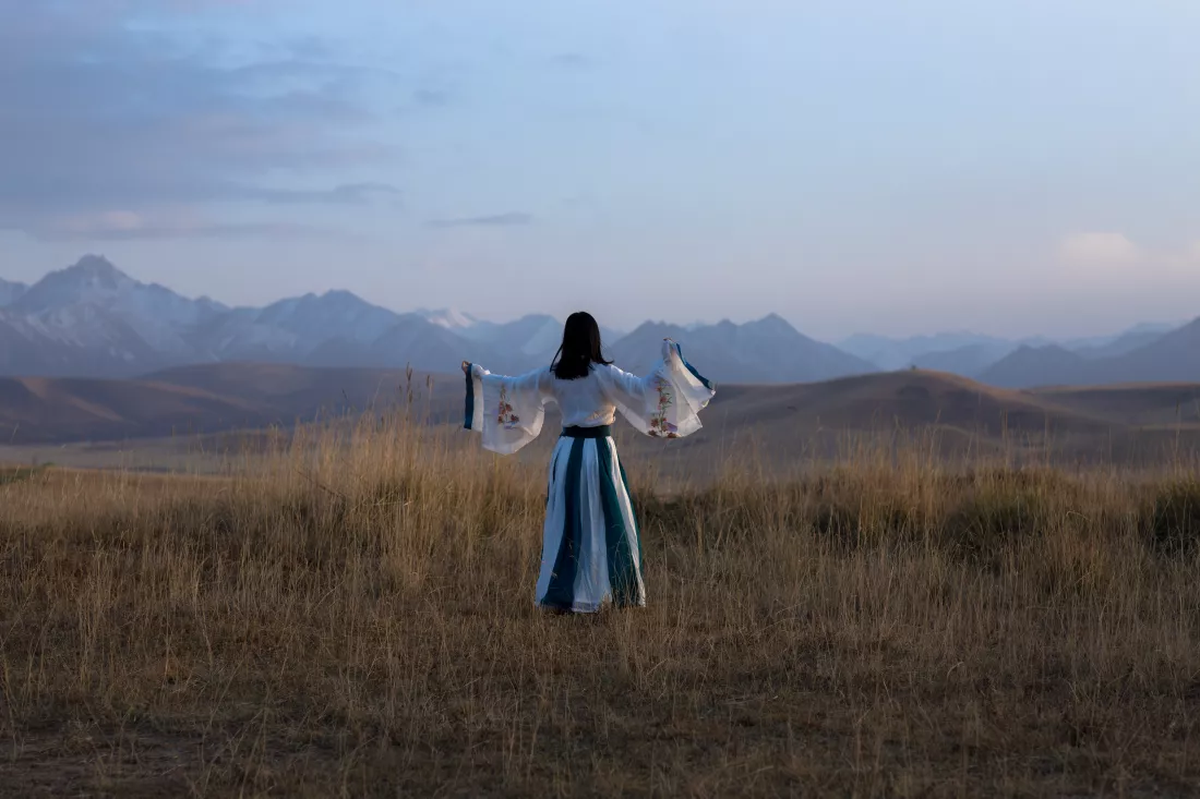 rear-view-woman-standing-mountain