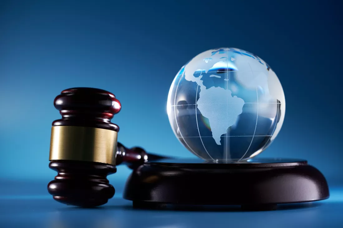 gavel-hammer-glass-globe-against-blue-background