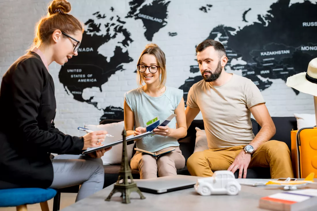young-lovely-couple-sitting-with-manager-travel-agency-office-prepairing-summer-vacation