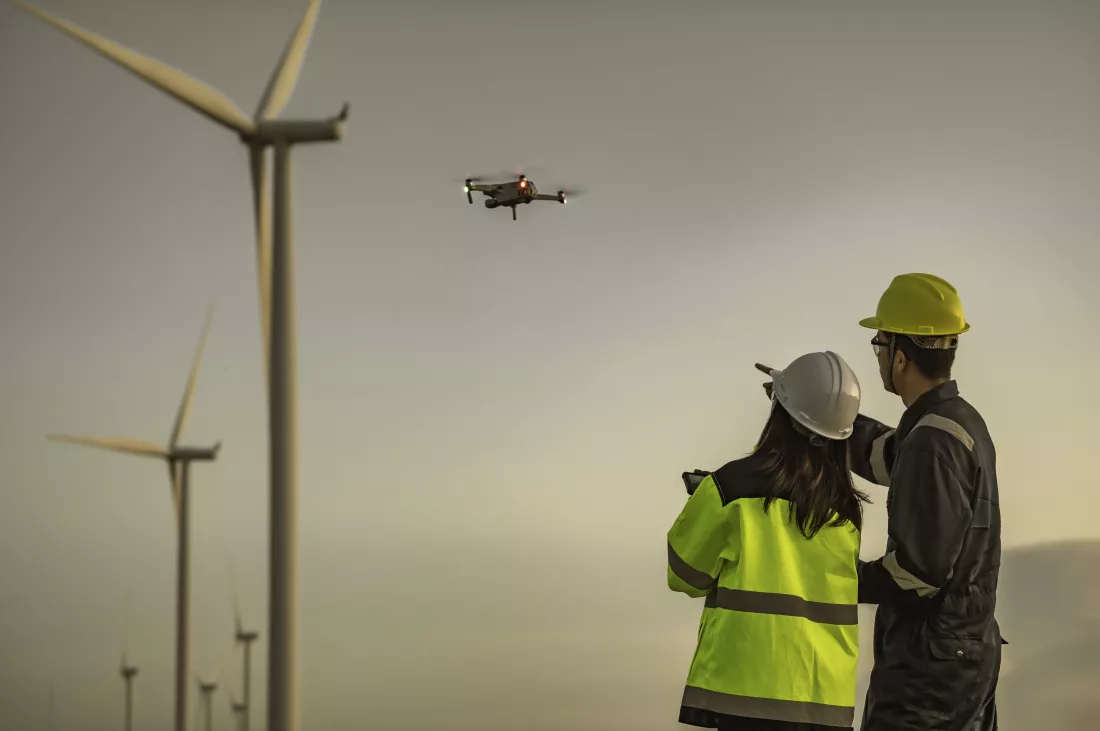 two-engineers-working-holding-report-wind-turbine-farm-power-generator-station-mountainthailand-peopletechnician-man-woman-discuss-about-workxause-drone-view-from-high-angle