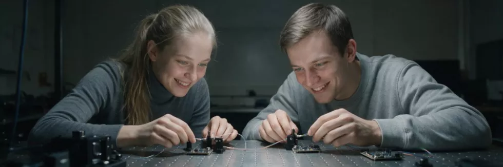 students-adjusting-components-on-an-optical-table