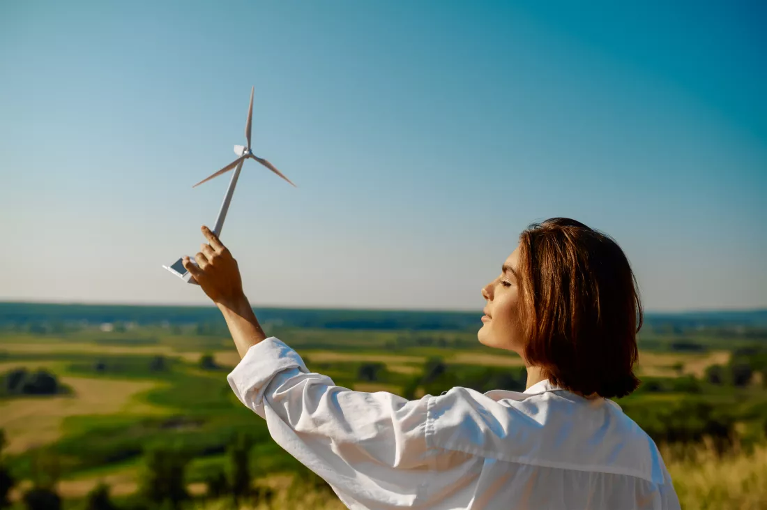 woman-holds-wind-turbine-model-field
