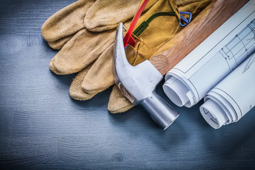 safety-gloves-rolled-blueprints-hammer-goggles